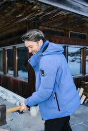 Ein herr trägt die Wengen Jacke von Belowzero beim Holzhacken.
