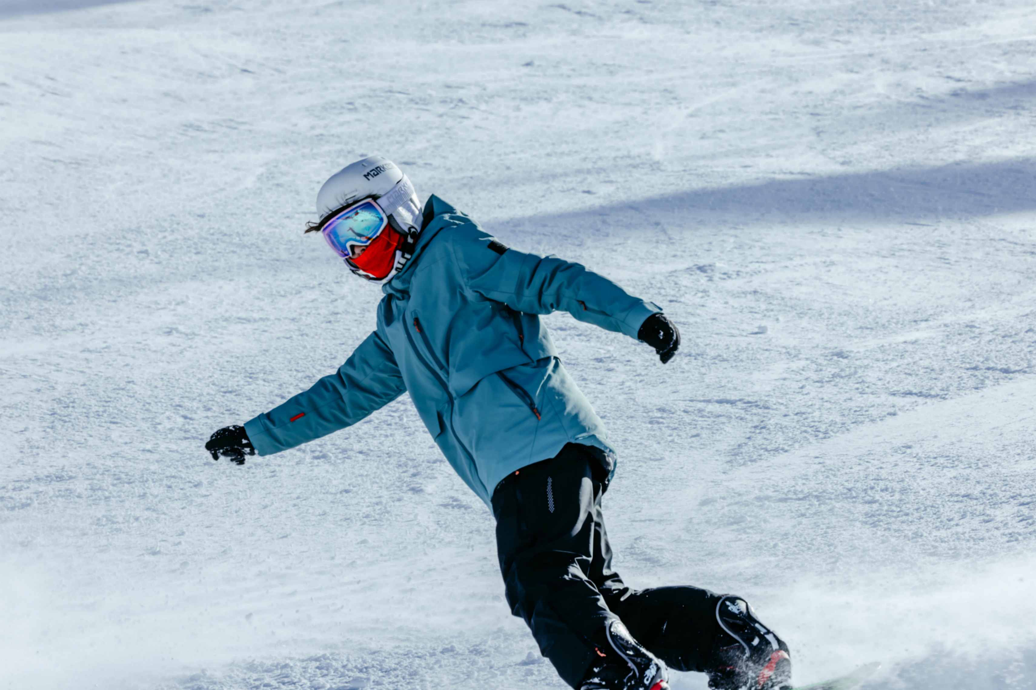 Ein Junge mit Belowzero Bekleidung wirft Schnee in die Höhe