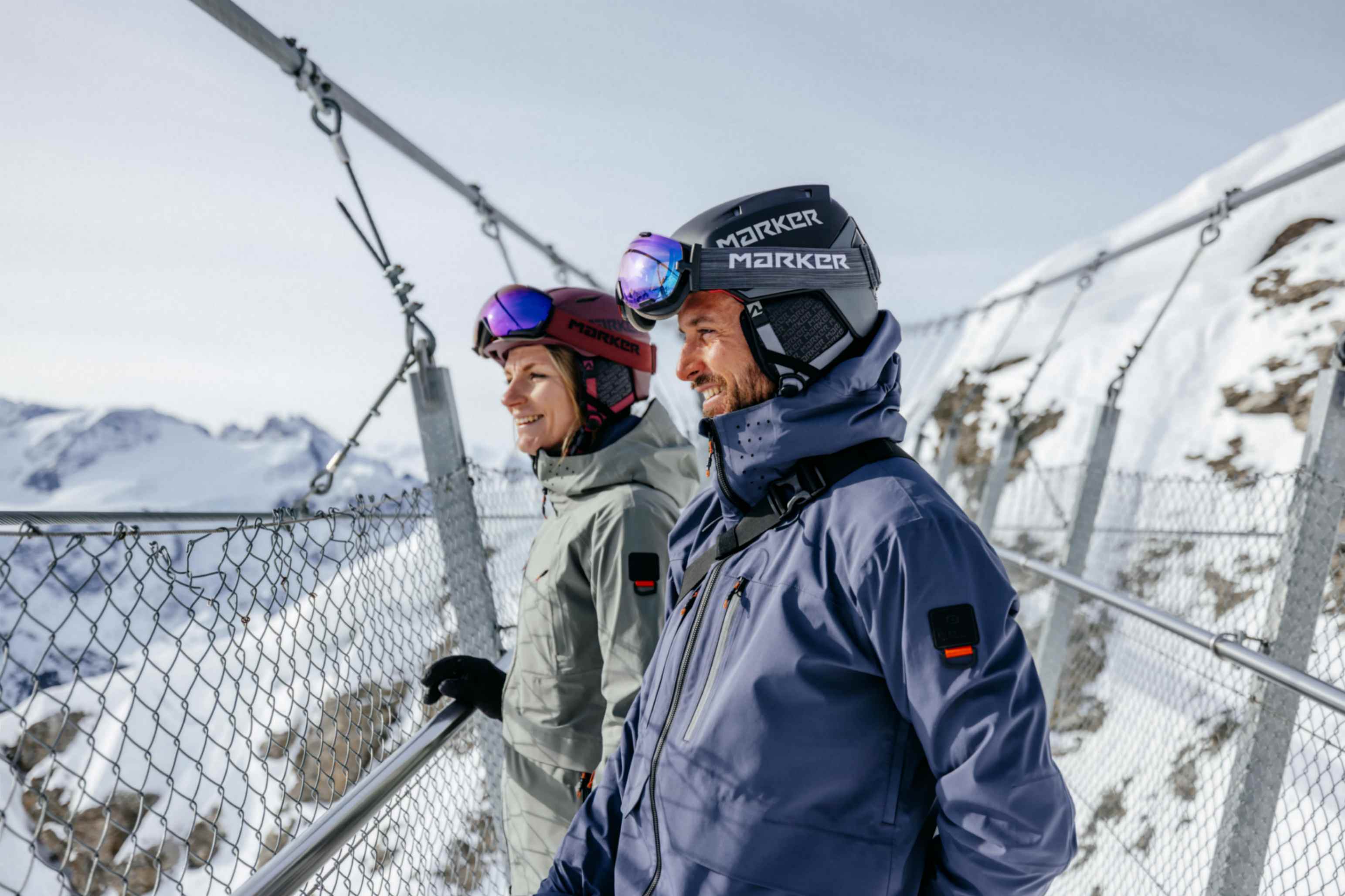 EIne Dame und ein Herr geniessen die Aussicht in den Bergen. Sie tragen beide Belowzero Bekleidung.