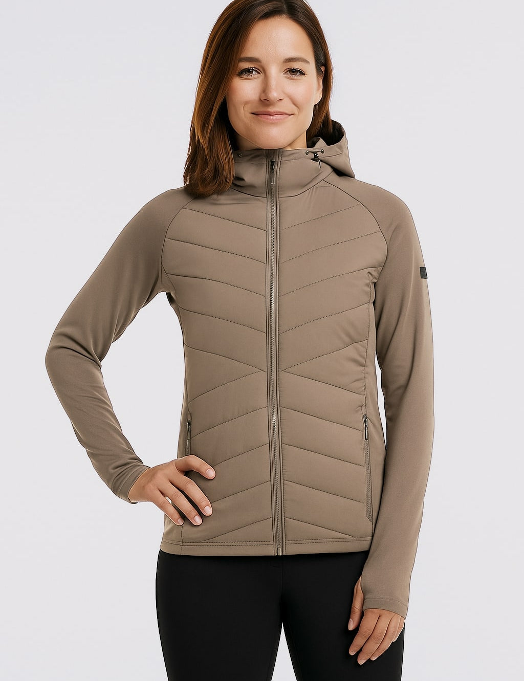 Eine Dame mit einer braunen Belowzero Hybrid Jacke
