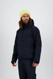 Dunkelblaue Herren-Skijacke von Belowzero mit Kapuze, seitlichen Reissverschlusstaschen und markanter Ärmeltasche inklusive Zippuller, kombiniert mit passender Skihose und neongelber Strickmütze.