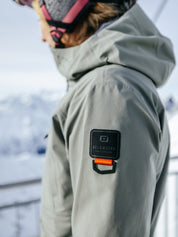 Eine Dame trägt die Nendaz Jacke von Belowzero in den Bergen.