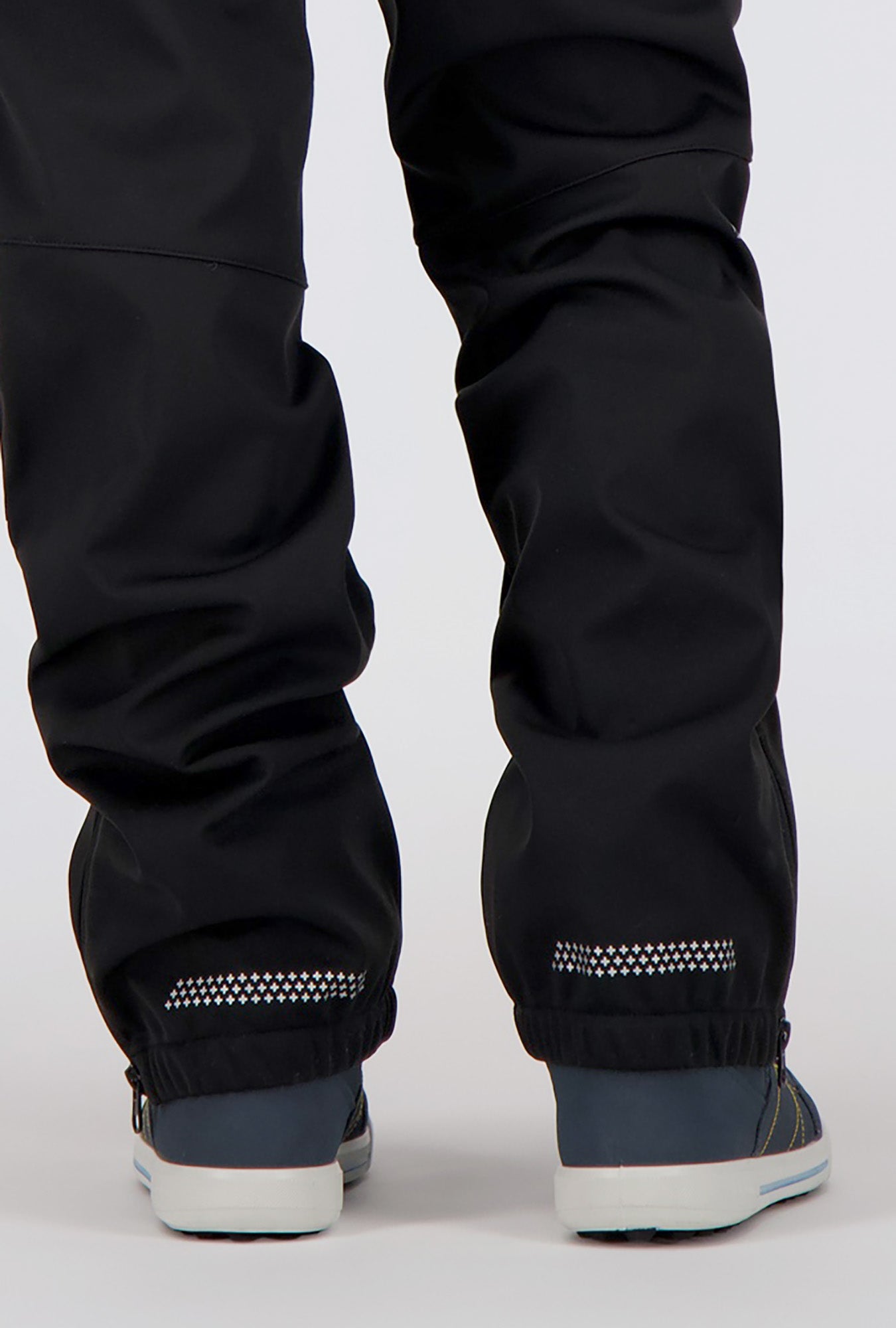 Detailansicht der Beine eines Jungen welcher eine schwarze Softshellhose von Belowzero trägt.