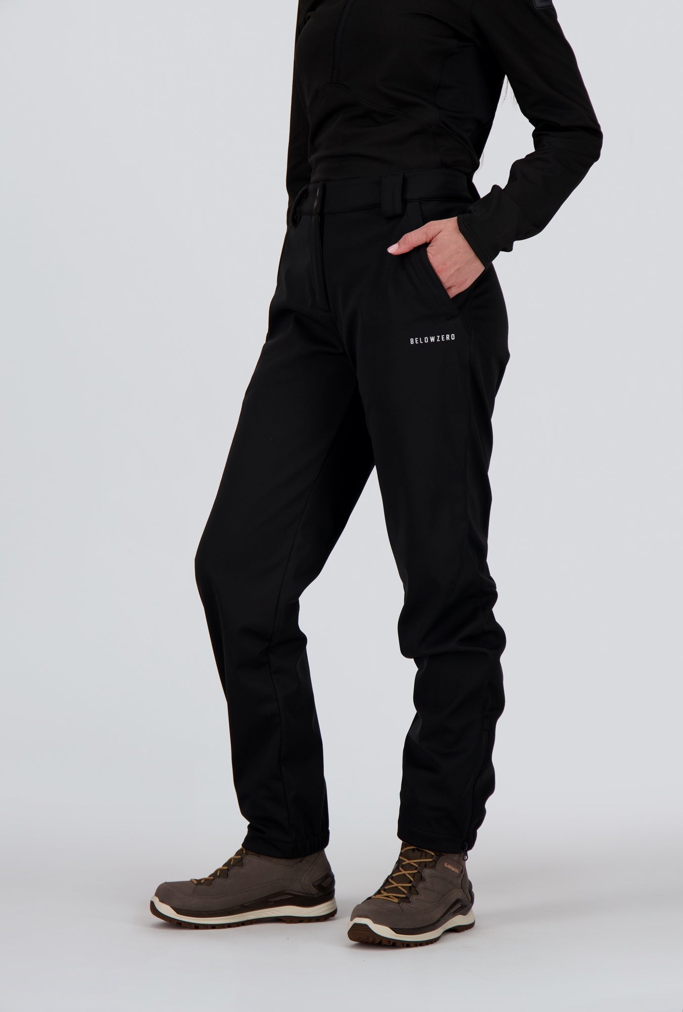 Frontansicht einer Dame welche eine schwarze Softshellhose von Belowzeroträgt.