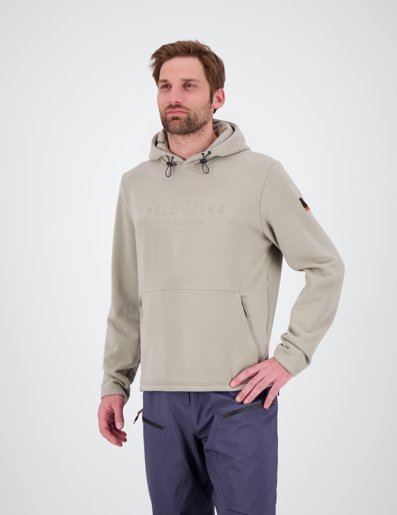 Frontansicht des dry moss Herren Tech Hoodie Brig von Belowzero
hellgrüner Herren-Kapuzenpullover von Belowzero mit Kapuzenkordelzug, dezenter Logo-Stickerei auf der Brust und Kängurutasche mit Reißverschlüssen, kombiniert mit einer dunkelblauen Outdoor- bzw. Skihose.