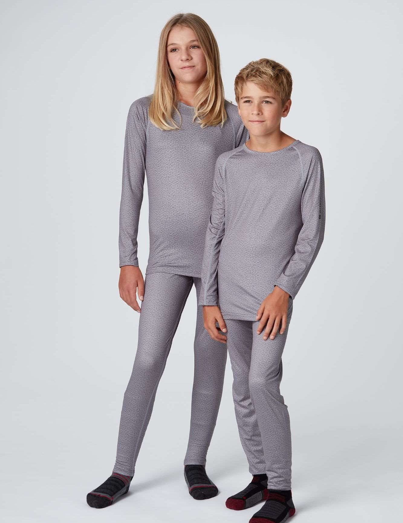 Frontansicht eines Mädchen und Jungen welche ein graues Longsleeve und Long Pants Baselayer Set Medium Light in grau tragen von Belowzero