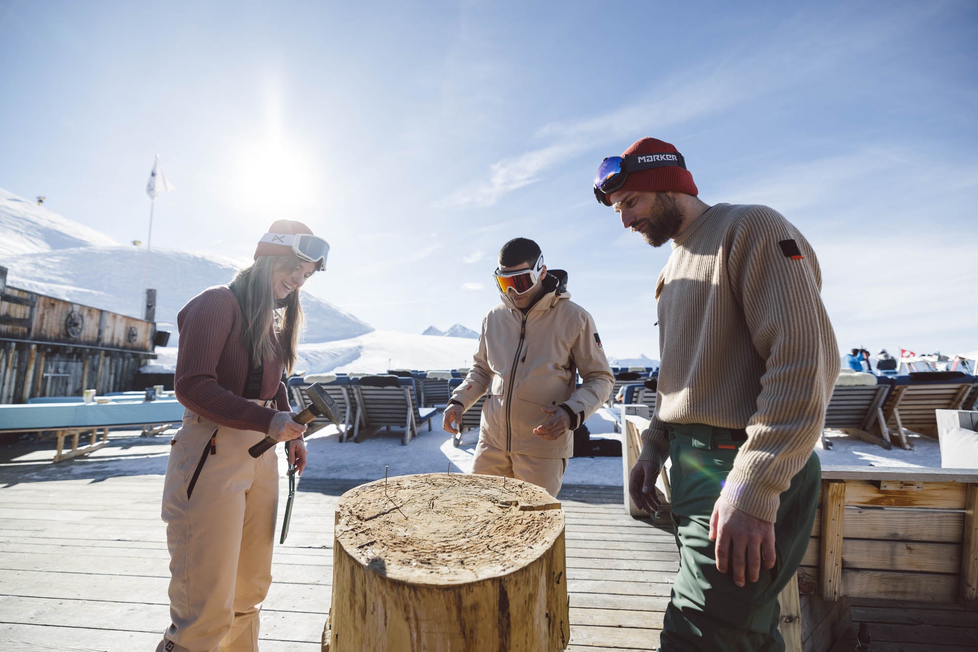 Drei Personen sind in einer Berghütte und versuchen Ihr glück beim Nageln dabei tragen sie Belowzero Bekleidung