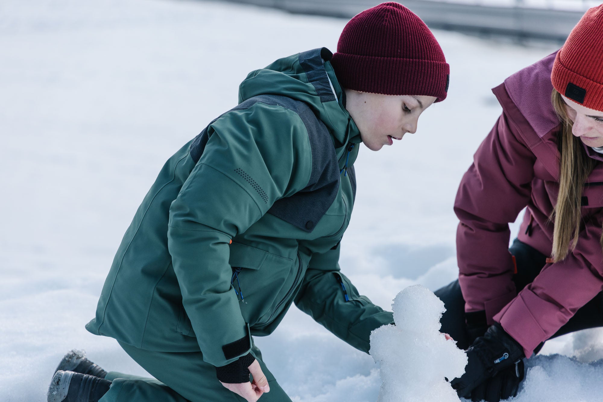 Ein Junge mit Belowzero Bekleidung spielt im Schnee