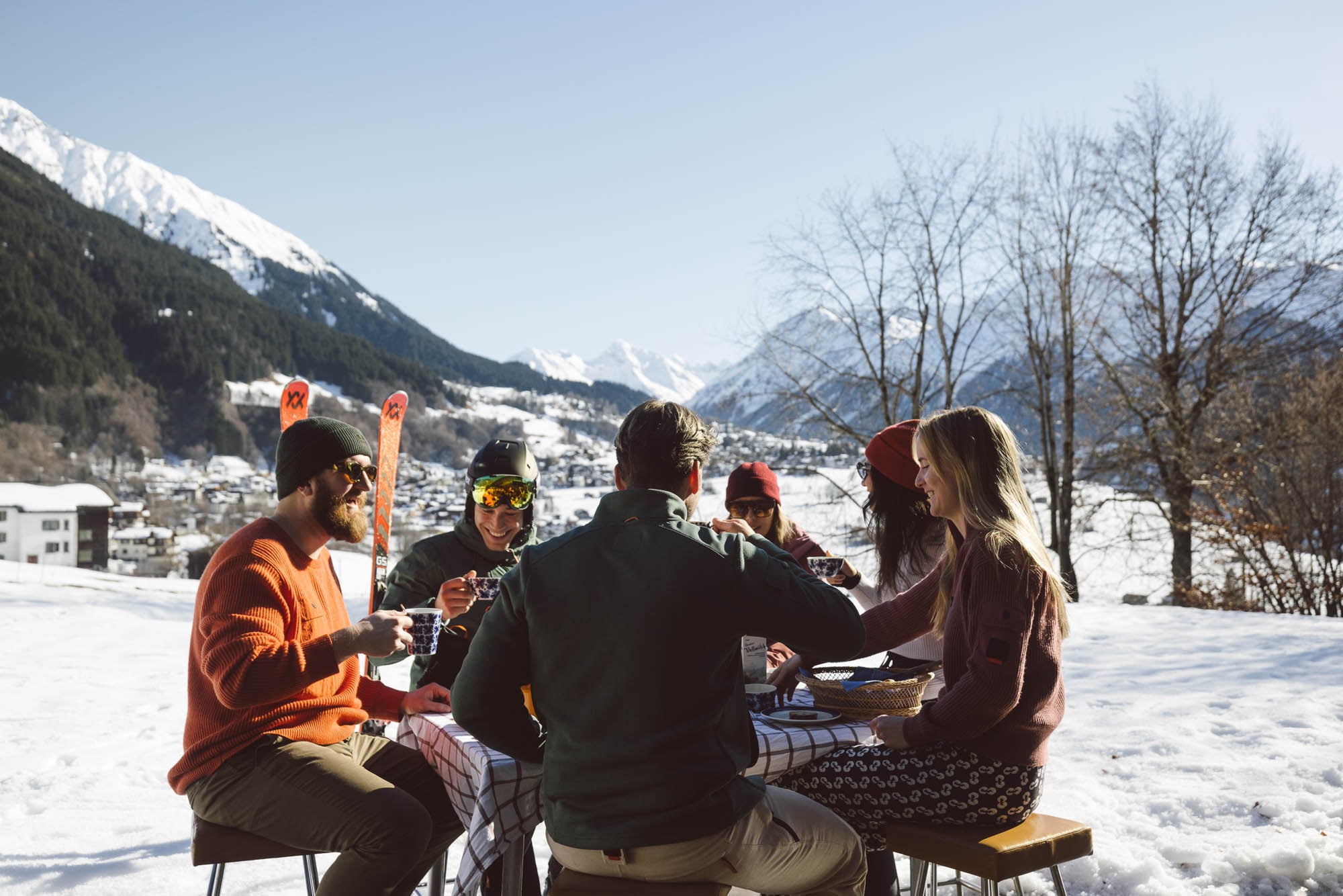 Eine Gruppe Menschen sitzt am Tisch mit Belowzero Bekleidung und ist ein Frühstück