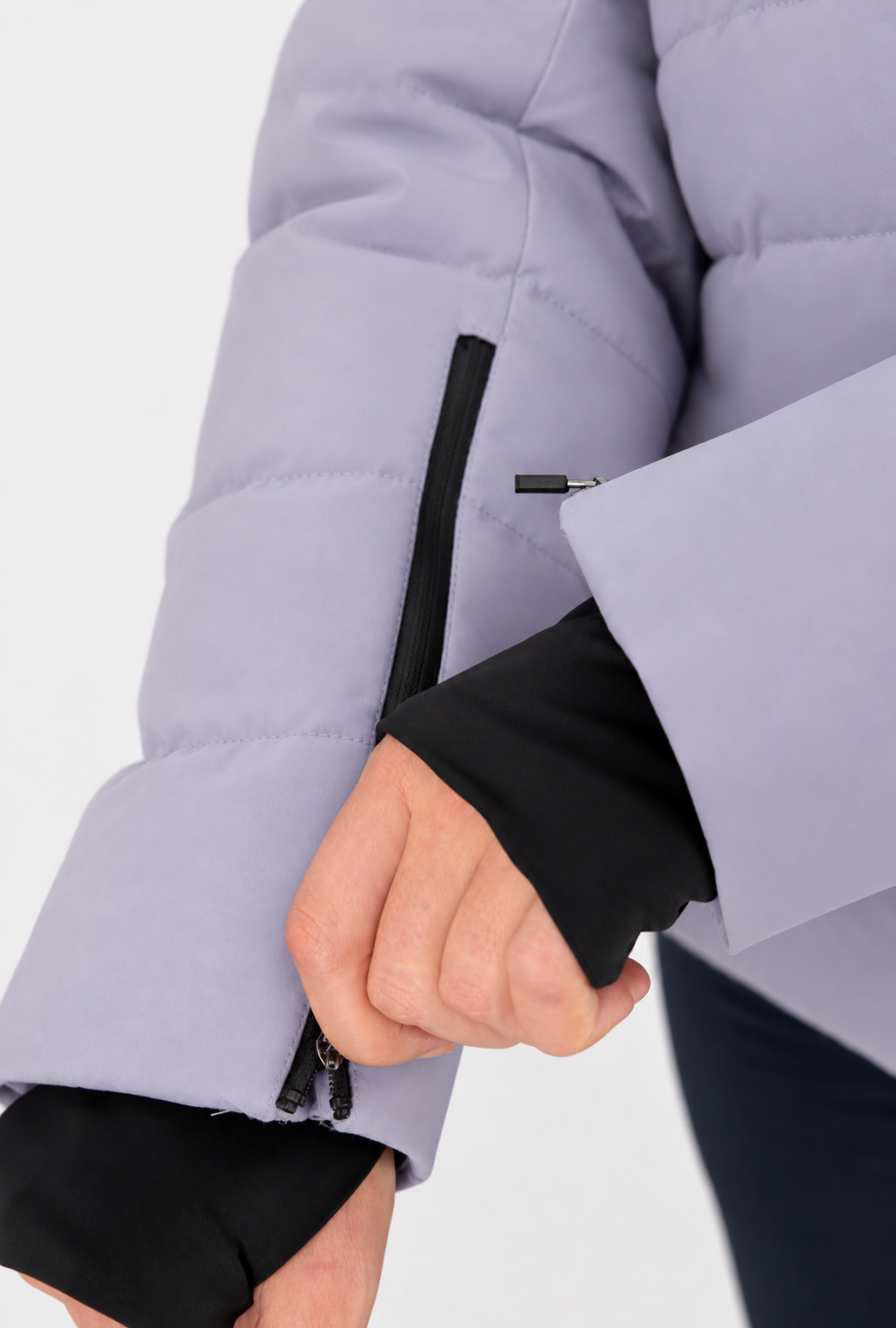 Belowzero Damen Skijacke in Flieder – Detail des Ärmels mit integrierter schwarzer Schneemanschette und praktischer Reissverschluss-Skipasstasche am Unterarm.