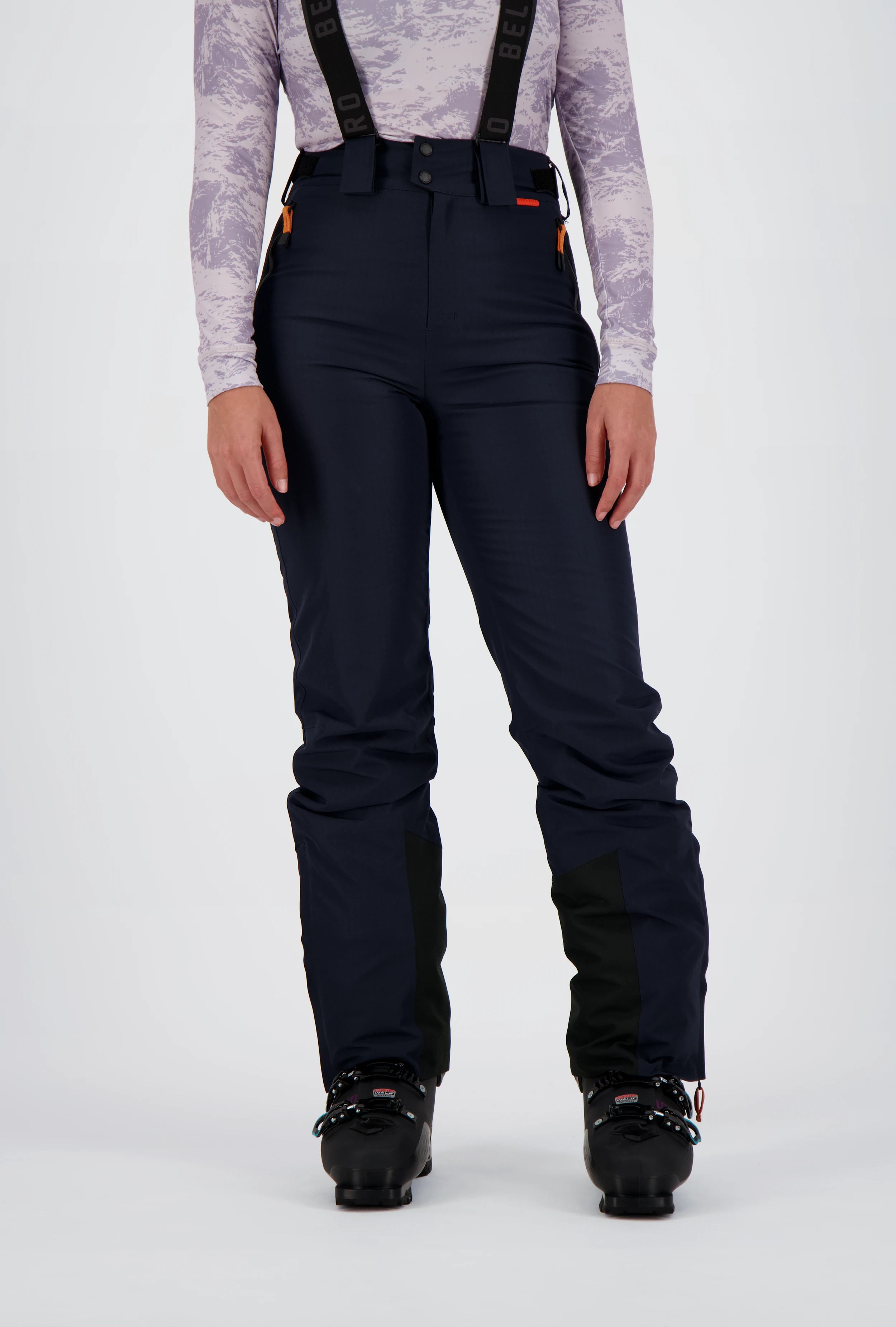 Frontansicht einer dunkelblauen Belowzero Damen Skihose mit verstellbaren Hosenträgern, verstärktem Kantenschutz am Beinabschluss und schwarzen Skischuhen.