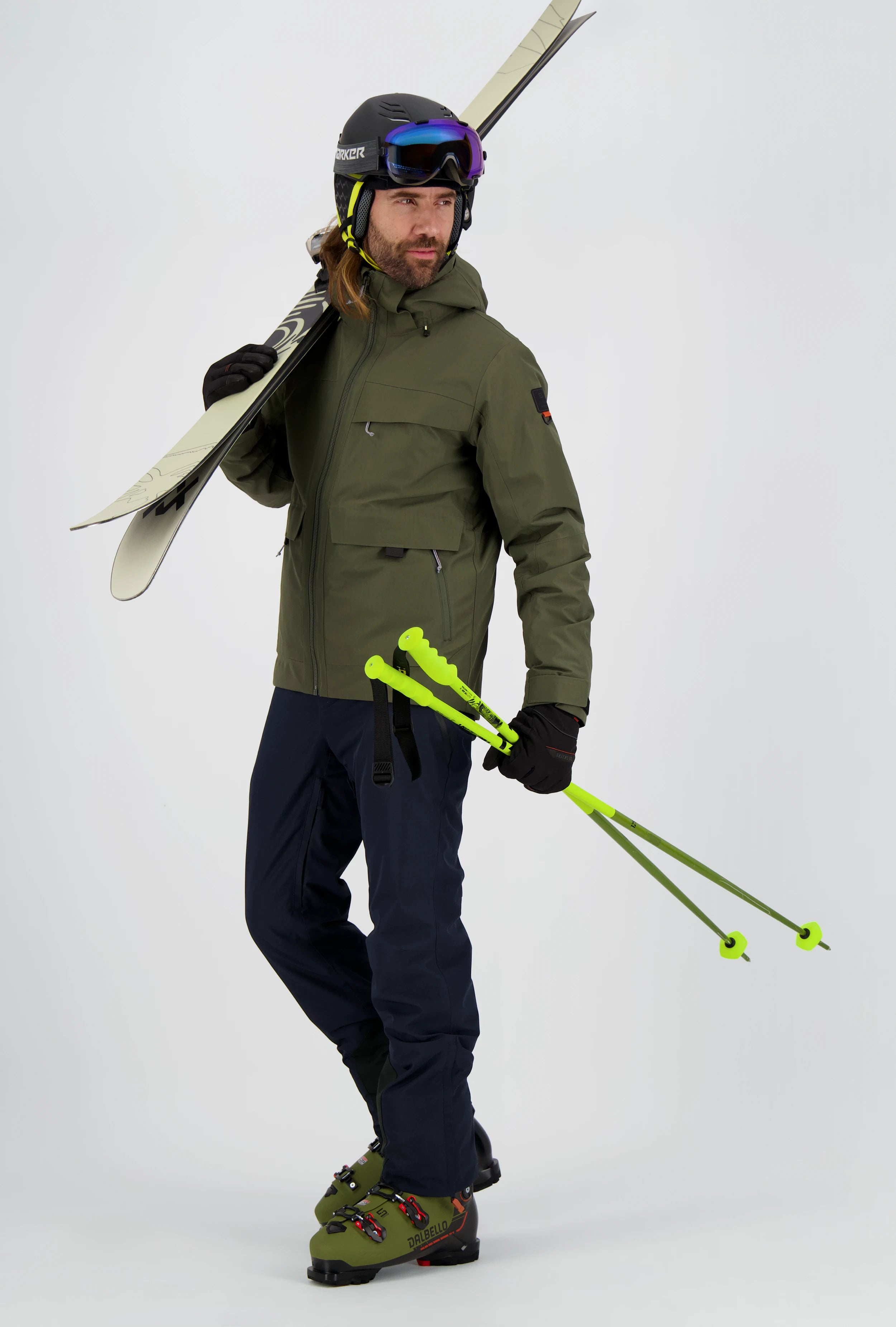 Mann in kompletter Belowzero Herren-Skibekleidung von der Seite: Olivgrüne Skijacke mit Kapuze und Brusttasche, kombiniert mit einer dunkelblauen Skihose und schwarzen Handschuhen.