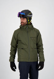 Mann trägt eine olivgrüne Belowzero Herren-Skijacke mit Kapuze und Taschen, dunkle Skihose, schwarze Handschuhe sowie einen Skihelm mit Skibrille.