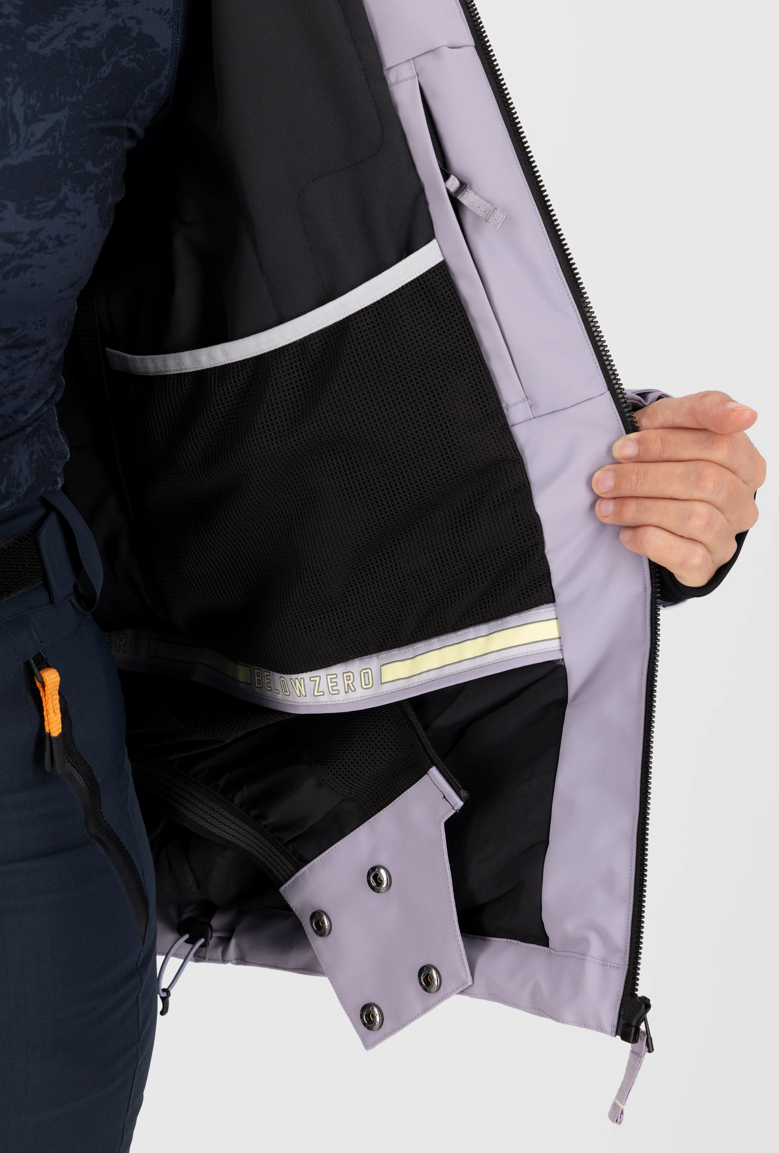 Innenansicht einer fliederfarbenen Belowzero Damen Skijacke mit Schneefang, Reissverschluss-Innentasche und grosser Mesh-Netztasche für Skibrille oder Zubehör.