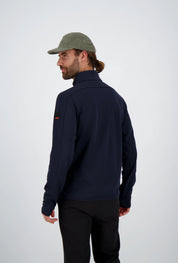 Rückenansicht eines Mannes mit gebundenen Haaren und olivgrüner Cap in einer dunkelblauen Belowzero Herren Fleecejacke Midlayer mit Ärmel-Patch und schwarzer Hose.
