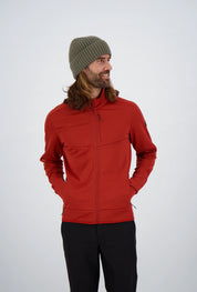 Frontansicht eines Mannes mit langen Haaren und olivgrüner Beanie-Mütze in einer roten Belowzero Herren Fleecejacke Midlayer mit Brusttasche und schwarzer Hose