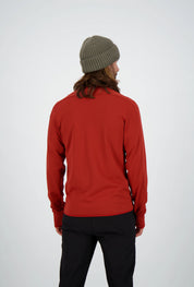 Rückenansicht eines Mannes mit langen Haaren und olivgrüner Beanie-Mütze in einer roten Belowzero Herren Fleecejacke  Midlayer und schwarzer Hose.