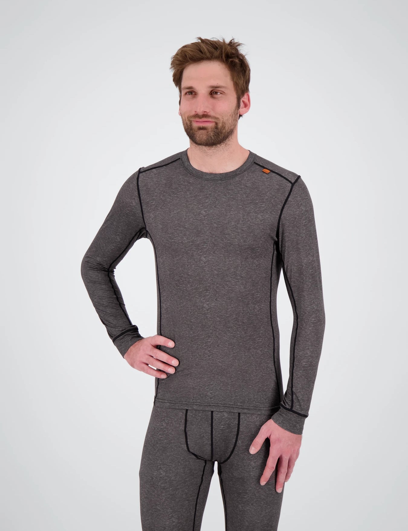 Eine Frontansicht eines Herren der ein dunkelgrau meliertes Medium Light Longsleeve Shirt von Belowzero trägt